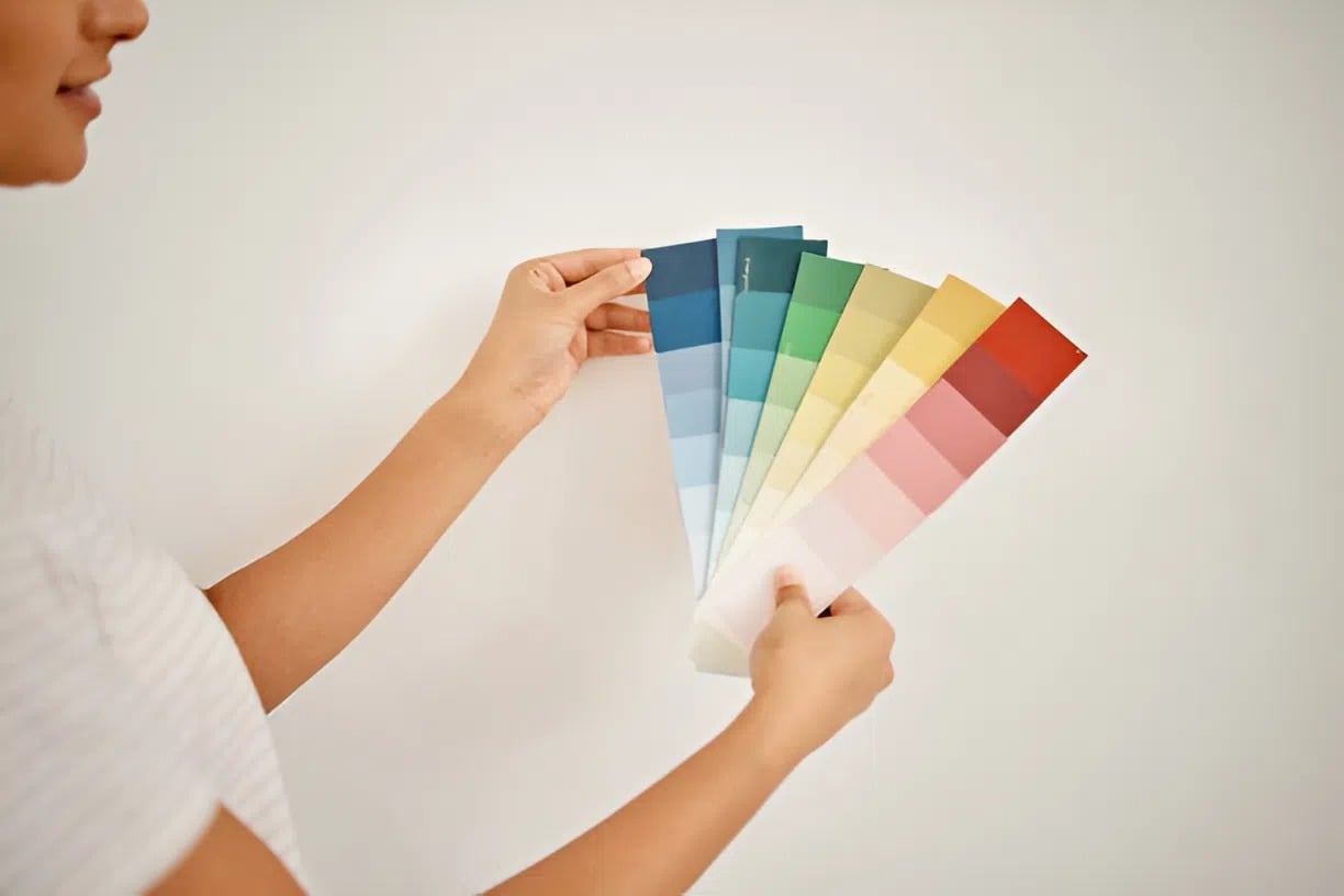 Woman holding interior paint color cards