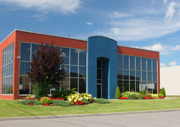 Commercial building with red brick walls and landscaped finishes by an exterior painter in Newbury, MI.