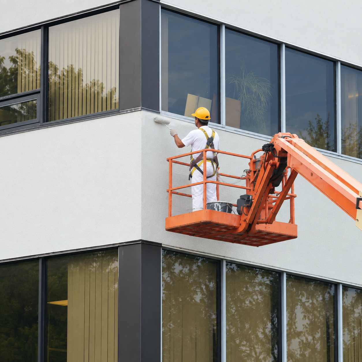 A painting company in Woodstock, VT applying exterior paint to a commercial office building.